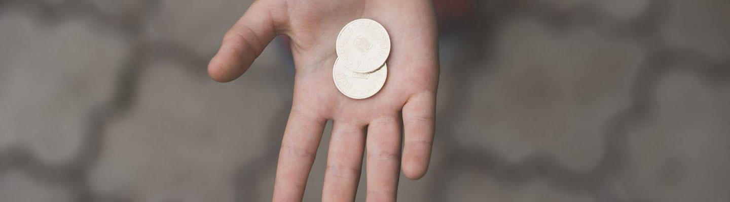 Offene Hand hält 2 Münzen: Unter welchen Umständen können Sie Blutzuckerteststreifen kostenlos erhalten?