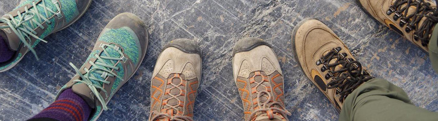 Wanderschuhe von 3 Personen auf Steinboden: Gesundheitswandern tut Menschen mit Diabetes gut.