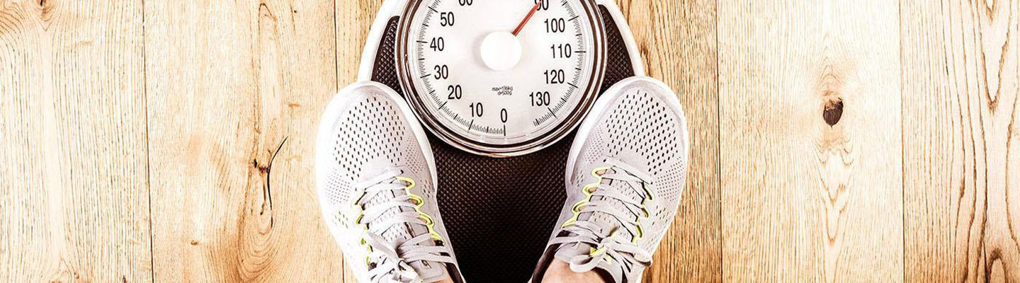 Person auf Waage kontrolliert, ob sie durch Diabetes eine Gewichtszunahme feststellen kann.
