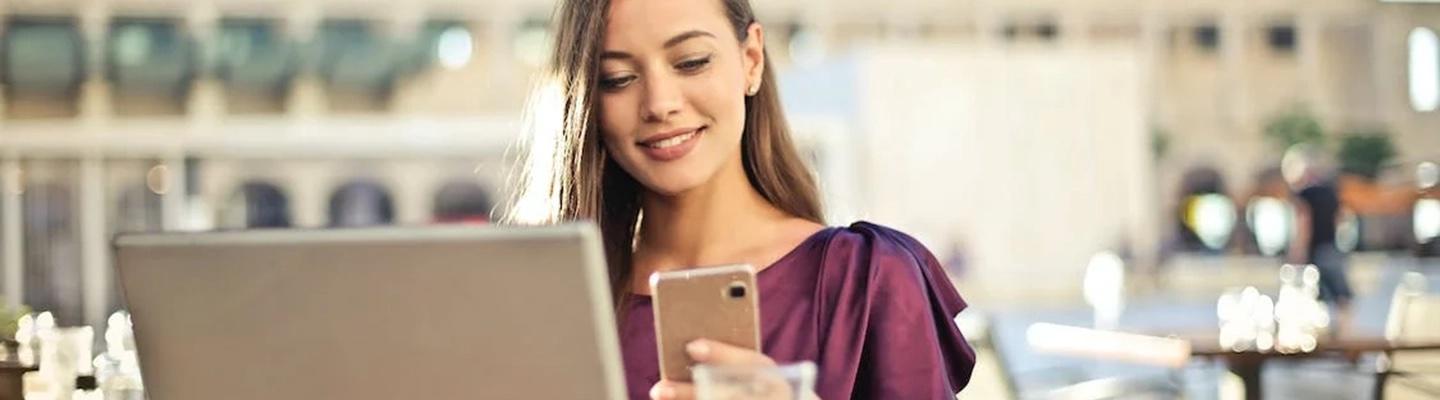 Frau im Restaurant berechnet die FPE für ihr Essen am Smartphone.