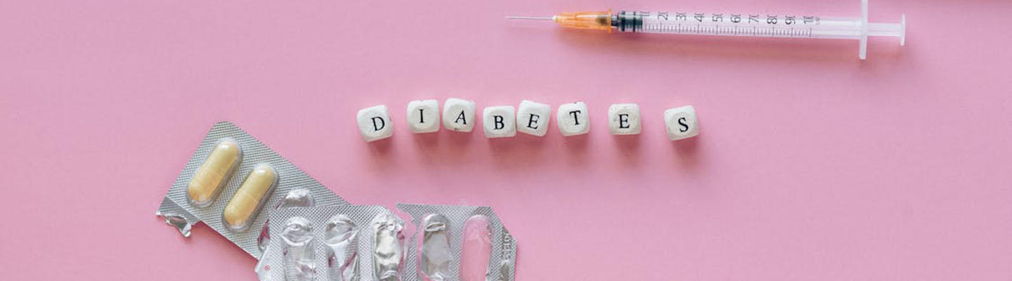 Foto von Diabetes-Medikamenten in Form von Spritzen und Tablettenblister mit einem Diabetes-Schriftzug in der Mitte.