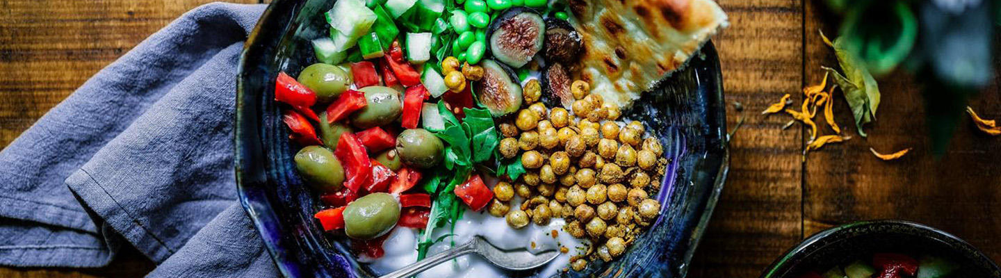 Vegan und Diabetes: Eine Bowl mit Salat, Kichererbsen, Feigen, Dressing und Fladenbrot.