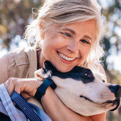 Frau kann dank der optimalen Tragemöglichkeit ihrer Insulinpumpe unbeschwert mit ihrem Hund spielen.