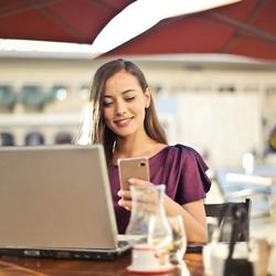 Frau im Restaurant berechnet die FPE für ihr Essen am Smartphone.