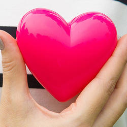 Bei Diabetes ist das Risiko für Schlaganfall und Herzinfarkt erhöht: Frau hält sich ein Herz aus Plastik vor die Brust.