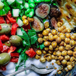 Vegan und Diabetes: Eine Bowl mit Salat, Kichererbsen, Feigen, Dressing und Fladenbrot.
