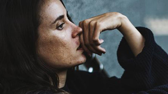 Frau mit Diabetes und Depression lehnt traurig an einer Wand.